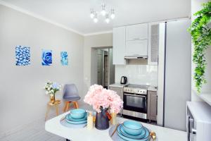a kitchen with a table with pink flowers on it at Arbat Central Apartment in Almaty +11 photos