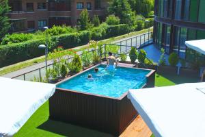 a person in a swimming pool on a balcony at Hotel Jardines de Uleta Suites in Vitoria-Gasteiz