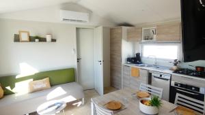 una piccola cucina con tavolo e una sala da pranzo di Camping Les Brillas a Les Moutiers