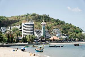 a beach with boats in the water and buildings at Phố Biển 3 in Vung Tau