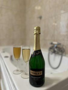 a bottle of champagne and two wine glasses on a bath tub at Vidéki Vendégház in Doboz +18 photos