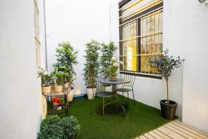 un balcone con tavolo, sedie e piante in vaso. di Appartamento Toscanini a Verbania