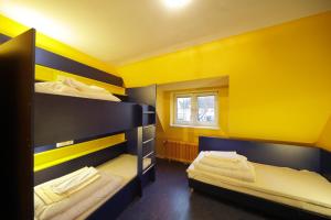 two bunk beds in a room with yellow walls at Bed’nBudget Expo-Hostel Dorms in Hannover +15 photos