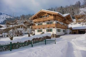 a large wooden house in the snow at Ferienhaus Evi - Sonnbichl in Brixen im Thale