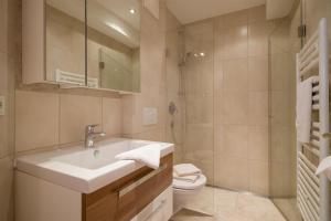 a bathroom with a sink and a toilet and a shower at Ferienhaus Evi - Sonnbichl in Brixen im Thale