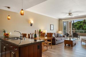 a kitchen and living room with a couch and a table at Honua Kai Konea 230 in Kahana
