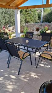a picnic table and chairs on a patio at Kuća za odmor Neva in Nečujam