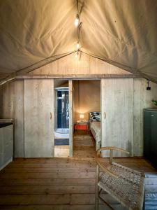 ŁawkiWolny Las Glamping na Mazurach的帐篷内的一个床位房间