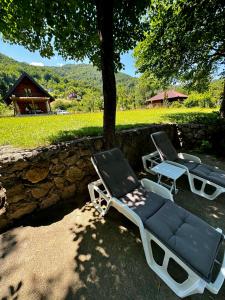 two lounge chairs sitting next to a stone wall at Deni&Dino in Lohovo