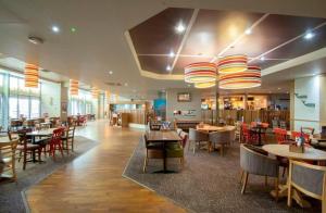 a dining room with tables and chairs and a restaurant at Luxury Lodge at Parkdean Camber Sands Resort in Camber