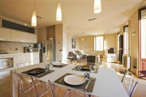 una cucina e un soggiorno con tavolo e sedie di Appartamento Toscanini a Verbania