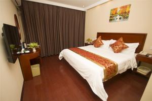 Cette chambre comprend un grand lit et un bureau. dans l'établissement GreenTree Inn Weihai Qingdao North Road Branch, à Weihai