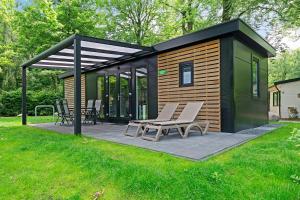 a small cabin with chairs on a patio at RCN het Grote Bos in Doorn +15 photos