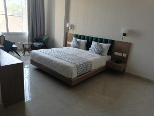 加姆布The Golden Valley Hotel and Resorts的房间里有一张大床的卧室