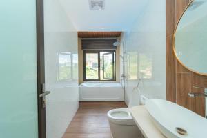 Un baño con inodoro, lavabo y espejo. en Mây ơi homestay- Venuestay, en Sa Pa