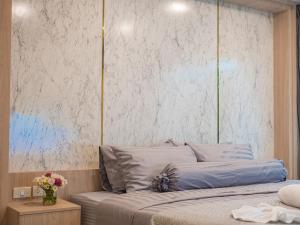 a bedroom with a bed and a white wall at Lamai Beach - Apartment Leo in Nathon Bay