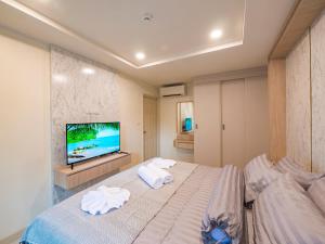 a bedroom with a bed and a flat screen tv at Lamai Beach - Apartment Leo in Nathon Bay