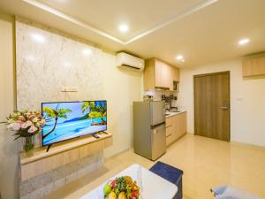 a living room with a television and a kitchen at Lamai Beach - Apartment Leo in Nathon Bay +20 photos