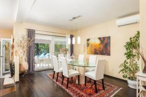 a dining room with a glass table and white chairs at Villa Rupena in Buzet