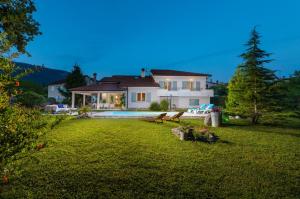 a house with a yard with a swimming pool at Villa Rupena in Buzet
