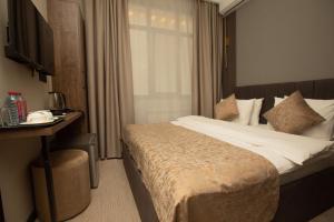 a hotel room with a large bed and a desk at The Nest Hotel Baku in Baku
