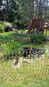 a fence in front of a park with a playground at Le Chalet de la Répandise - Gîte Vosges 9 pers, Spa privé & Piscine - Proche Gérardmer in Laveline-du-Houx +68 photos