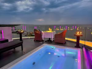 a balcony with a hot tub and a table and chairs at Panorama Suites & Spa - Adults Only in Stomio