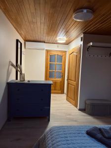 Schlafzimmer mit blauer Kommode und Holztür in der Unterkunft Saulėlydžio apartamentai in Palanga