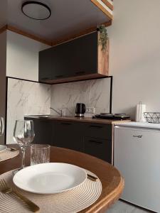 eine Küche mit einem Holztisch mit einem Teller darauf in der Unterkunft Saulėlydžio apartamentai in Palanga