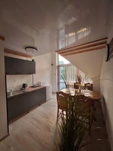 eine Küche und ein Esszimmer mit Tisch und Stühlen in der Unterkunft Saulėlydžio apartamentai in Palanga