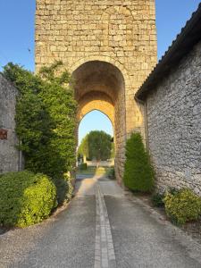 an archway in a stone building with a road at Le Gîte Eiffel Les Gîtes de l'Atelier in Gaudonville