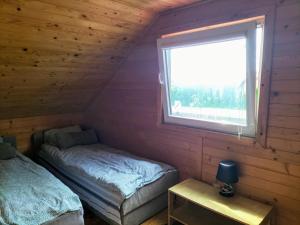 Un dormitorio con dos camas en una cabaña de madera. en Domki Pirat, en Władysławowo