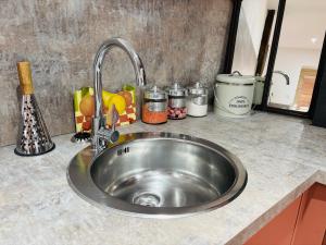 a stainless steel sink in a kitchen counter at Le Gîte Eiffel Les Gîtes de l'Atelier in Gaudonville