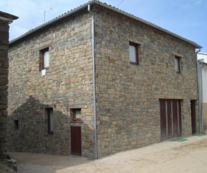 a large brick building with two doors and windows at Casa Luís Gonzaga in Bragança