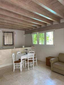 a dining room with a table and chairs and a couch at Casa con Piscina a Portoferraio in San Giovanni