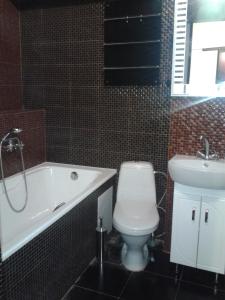 a bathroom with a toilet and a tub and a sink at Квартира в центрі біля Оперного театру in Lviv