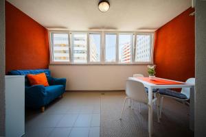 a living room with a table and a blue couch at Fleksibilni SelfCheckIns 168 - Zagreb - Studio - Parking - Lođa in Zagreb
