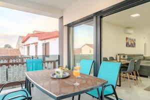 a table with two glasses of orange juice on a balcony at Apartment Midi in Vir