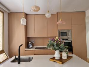 eine Küche mit einer Spüle und einer Vase mit Blumen auf einer Theke in der Unterkunft Las Suites de Platería in Murcia + 9 Fotos