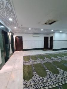 a room with a patterned floor in a building at Manazel Al Taqwa Hotel in Quai