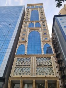 a tall building with a lot of windows at Manazel Al Taqwa Hotel in Quai