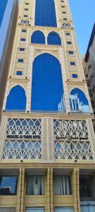 a tall tower with blue windows on a building at Manazel Al Taqwa Hotel in Quai