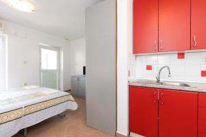 a kitchen with red cabinets and a sink at Apartments Ruza in Porat +58 photos