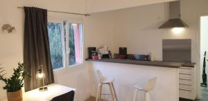 a kitchen with a counter and two stools in a room at apartment building features laundry facilities in Beauzelle
