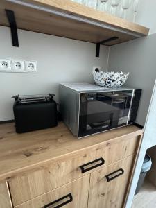 a microwave sitting on top of a wooden cabinet at Apartmán Vločka Tatranská Lomnica in Tatranská Lomnica