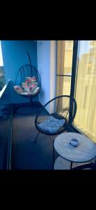 two chairs and a table on a balcony at DML Apartment in Mamaia Nord +5 photos