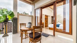 a room with a table and chairs and a bedroom at Usana House Ubud in Ubud