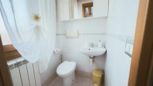 a white bathroom with a toilet and a sink at Casa Andrea by Ca-Sa Check in Chioggia