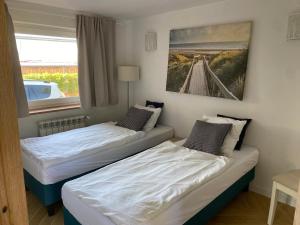 Leśne Apartamenty في هيل: سريرين في غرفة صغيرة بها نافذة +15 صورة