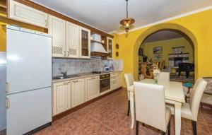 a kitchen with a table and a white refrigerator at House Marin in Drniš